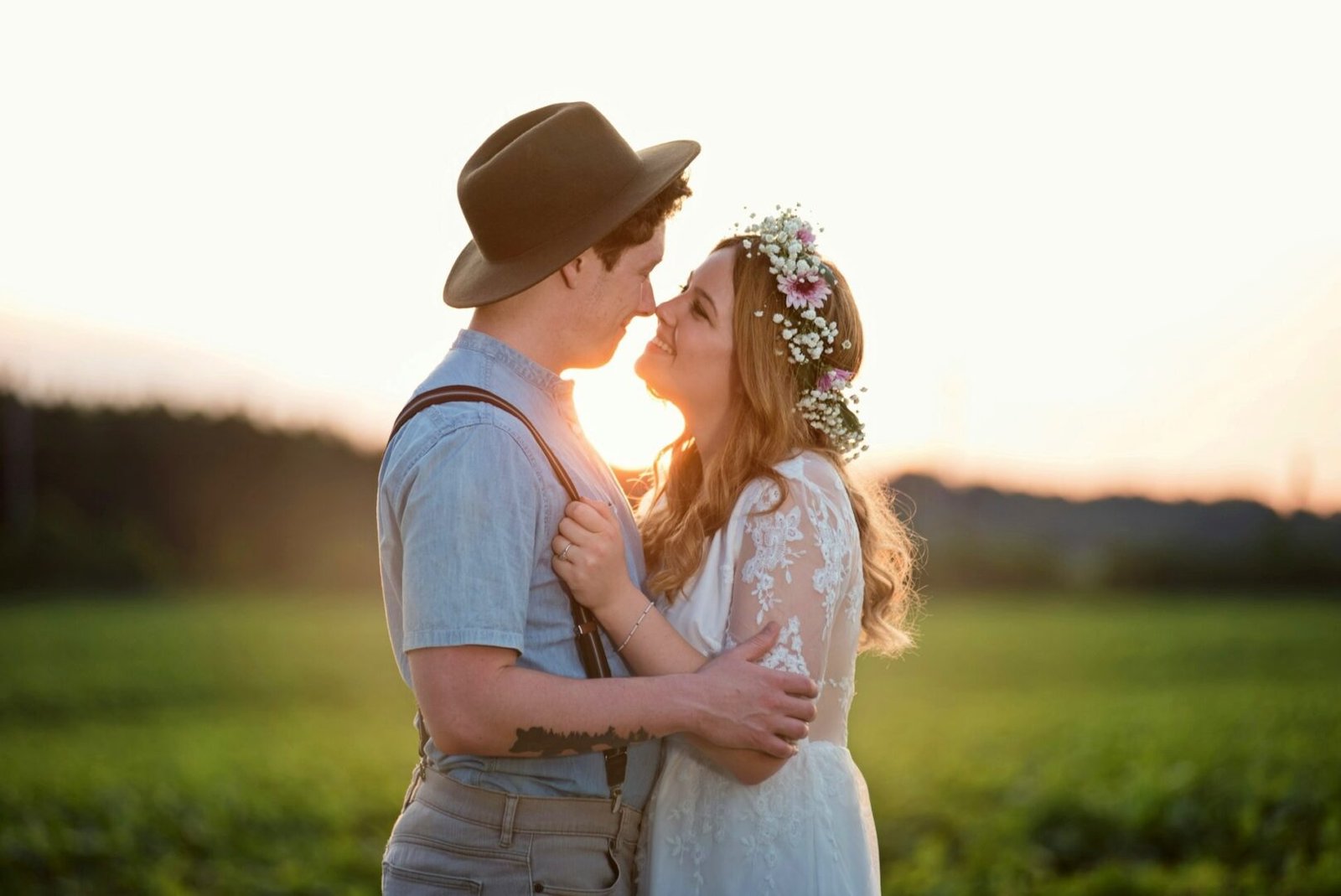 Sesión de pareja en medio de un atardecer en campo abierto