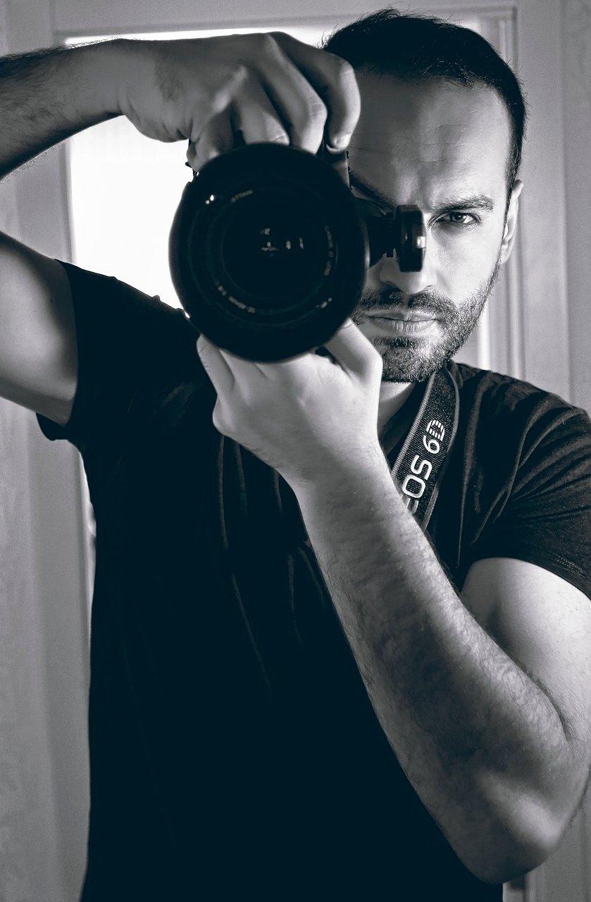 Retrato espontáneo de fotógrafo mientras apunta con su cámara.