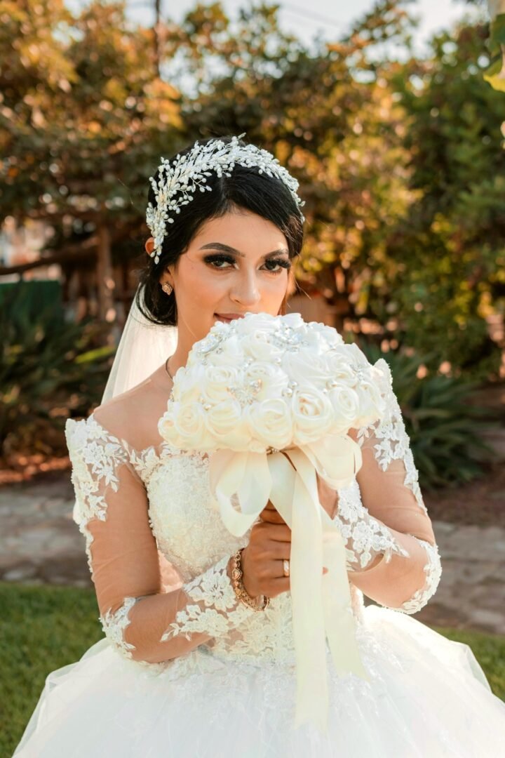 Novia feliz en el altar con vestido blanco completo y ramo de flores