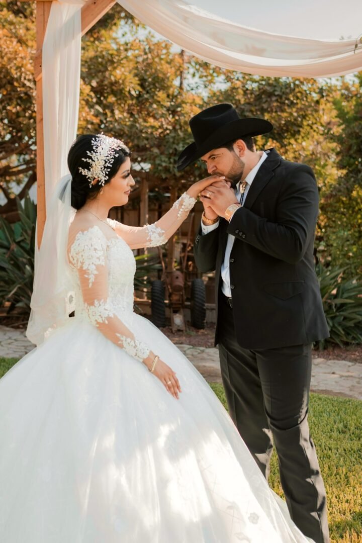 Momento romántico del Novio besando la mano de su esposa con ternura en el altar